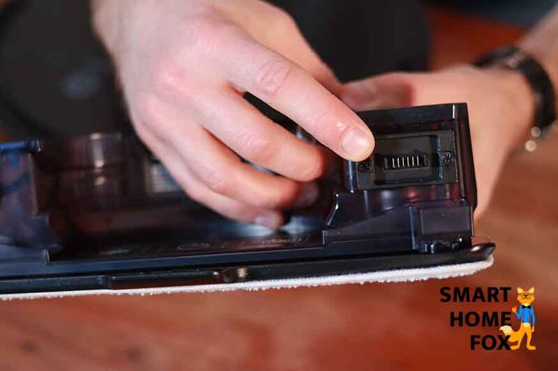 Ein Finger zeigt auf die elektrischen Kontakte am Wassertank des Ecovacs Deebot T9 AIVI